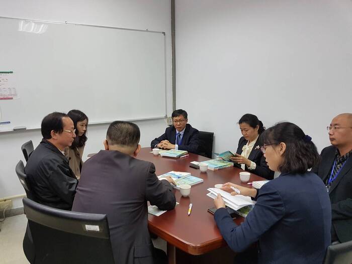 另一個角度合照兩方人員圍桌互相交流對談